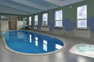 una gran piscina en una habitación con ventanas en Hotel Maggi, en Rogoźno