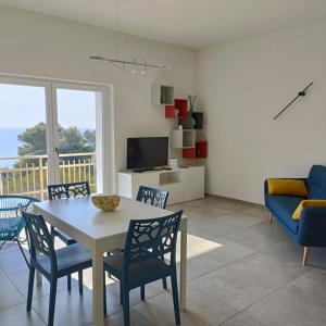 comedor y sala de estar con mesa y sillas en Living Castro Apartments, en Castro di Lecce