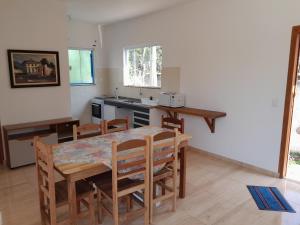 a kitchen and dining room with a table and chairs at Rancho Calamaris in Cananéia