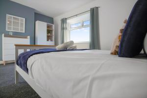 een slaapkamer met een groot wit bed en een raam bij Sweet Home with Backyard in Howden-le-Wear for 3 in Crook