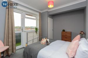 um quarto com uma cama e uma grande janela em Stunning 3 bedroom apartment Edinburgh em Edimburgo