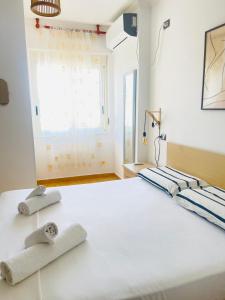 a bedroom with a large white bed with towels on it at Mediterranean Sea Apartments in Durrës