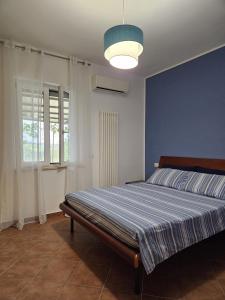 1 dormitorio con 1 cama con pared azul en Casa vacanze La Castellana, en Pianella