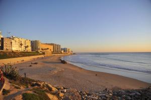 a view of a beach with buildings and the ocean at El Apartamento de Nueva in Cádiz