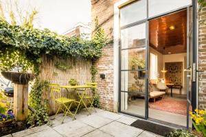 a patio with a table and chairs next to a brick wall at De DroomBoutique - Goud & Zilver Suites in Gorinchem