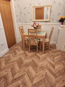 a dining room with a table and chairs on a wooden floor at Largs holiday flat in Largs