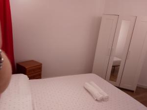 a bedroom with a bed with a mirror and a white bedspread at Mi Casa Es Tu Casa in Barcelona