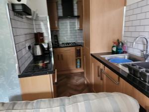 a small kitchen with a sink and a stove at Largs holiday flat in Largs