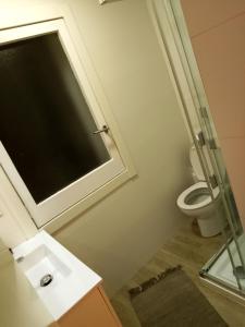 uma casa de banho com um WC e uma cabina de duche em vidro. em Mi Casa Es Tu Casa em Barcelona