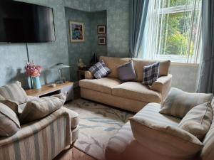 a living room with two couches and a flat screen tv at Largs holiday flat in Largs