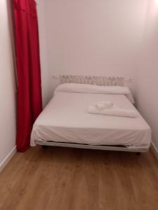 a bed in a room with a red curtain at Mi Casa Es Tu Casa in Barcelona