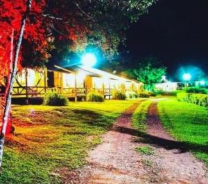 une maison éclairée dans la cour la nuit dans l'établissement POUSADA ITAIMBÉ, à Praia Grande