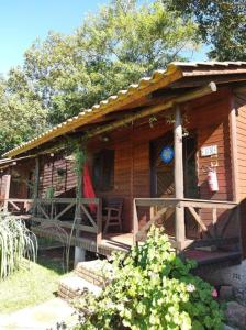 eine Holzhütte mit einer Veranda und einer Terrasse in der Unterkunft POUSADA ITAIMBÉ in Praia Grande