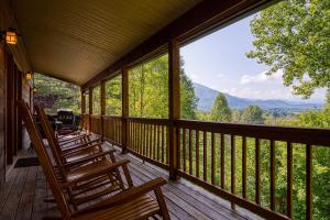 a porch with rocking chairs and a view of the mountains at Paradise Found, Hot Tub, Mtn Views, Game Room, 560 FREE tickets each paid day! in Sevierville