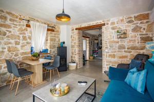 sala de estar con paredes de piedra y sofá azul en Villa Allegra Velici en Vižinada