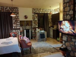 a kitchen and a living room with a bed and a tv at ΒΙΟΚΛΙΜΑΤΙΚΟ ΗΛΙΟΠΕΤΡΟΣΠΙΤΟ στην ΑΡΧΑΙΑ ΒΟΚΕΡΙΑ in Peraía