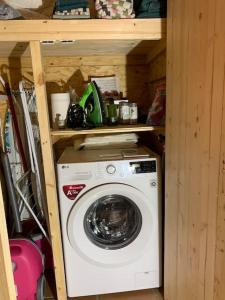 a washer and dryer in a wooden cabinet at Mysigt boende på landet nära naturen in Ödeshög