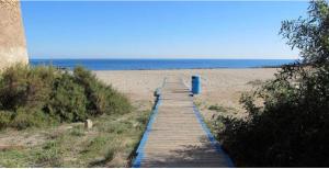 einen Holzweg zum Strand mit blauem Objekt darauf in der Unterkunft BEACH SUN SPIRIT, spa & gym in La Manga del Mar Menor