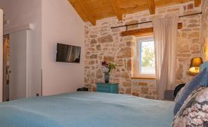 1 dormitorio con cama y pared de piedra en Villa Allegra Velici, en Vižinada