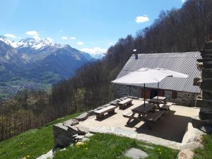 un tavolo da picnic e un ombrellone in cima a una montagna di CHALET AULIAN a Grust