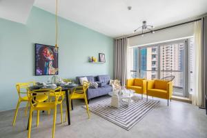 a living room with a table and yellow chairs at GuestReady - A breathtaking place with Marina view in Dubai