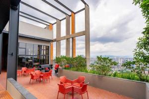 a balcony with red chairs and tables on a building at [Sky Infinity Pool] Modern Suite @ Mid Valley KL in Kuala Lumpur