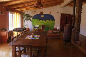 une chambre avec une table et des chaises ainsi qu'une grande peinture murale. dans l'établissement Vistas al Nevado, à Cachí