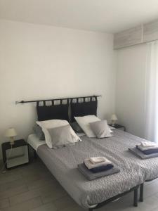 1 dormitorio con 1 cama con 2 toallas en Saint Cyprien Golf View 2 bedrooms Apartment , 900 m from the beach en Saint-Cyprien