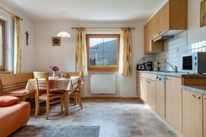 a kitchen with a table and a dining room at Obertegghof Wohnung Schartenblick in Sarntal
