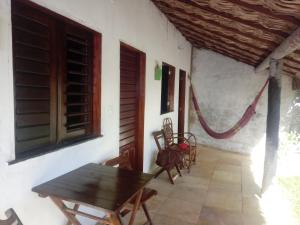 a porch with a wooden table and chairs on a house at Zion Land Canoa Quebrada in Aracati