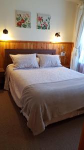 a bedroom with a large bed with two pillows at Departamento Acogedor Parque Suizo 800 Pucon in Pucón