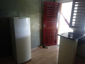a white refrigerator in a room with a red door at Zion Land Canoa Quebrada in Aracati