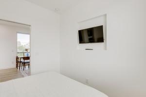 Dormitorio blanco con TV en la pared en Downtown Phoenix Apartment with Private Balcony, en Phoenix