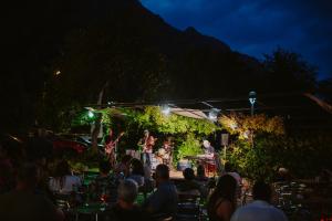 un grupo de personas viendo una banda en un escenario por la noche en Hotel Limone, en Limone sul Garda
