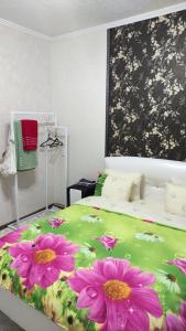 a bedroom with a bed with pink flowers on it at Restful sleep apartments in Karakol