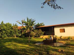 a person sitting at a table in a yard at Pouso Divino dos Pireneus in Pirenópolis