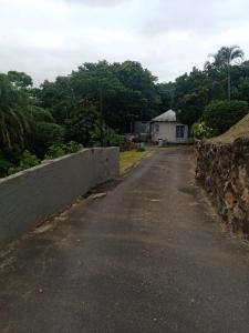 an empty road with a stone wall and a house at 17 Clubmed Resort in Hibberdene