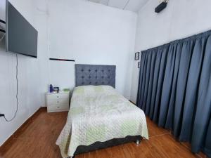 - une chambre avec un lit et une télévision dans l'établissement Martina House, à Iquitos