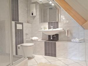 a white bathroom with a sink and a toilet at SMC Muenster in Münster