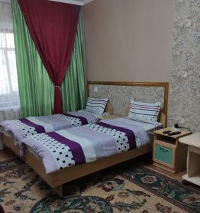 two beds sitting next to each other in a room at Restful sleep apartments in Karakol