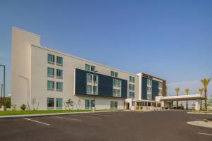 un edificio de oficinas con un estacionamiento delante de él en SpringHill Suites by Marriott Phoenix Goodyear en Goodyear