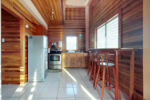 Kuchnia z drewnianymi ścianami i lodówką w obiekcie Roughrider Inn Gold Standard Certified w Caye Caulker