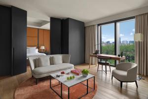 北京市にあるブルガリ ホテル 北京のベッドとリビングルームが備わるホテルルームです。