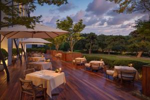 een restaurant met tafels en stoelen en een parasol bij Bulgari Hotel, Beijing in Beijing