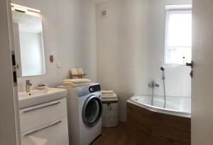 a bathroom with a washing machine next to a bath tub at Apartmán Kutička in Prešov