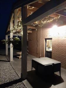 a patio with a bench in a building with lights at Le calme de la prairie de liège in Liège