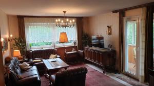 a living room with leather furniture and a television at Ferienhaus mit großem Garten in Bad Gandersheim