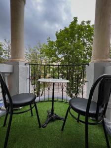 2 sillas y una mesa en un balcón con césped en Aparthotel VictoryHome, en Krivoy Rog