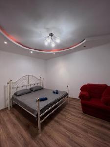 1 dormitorio con 1 cama y 1 sofá rojo en Aparthotel VictoryHome, en Krivoy Rog