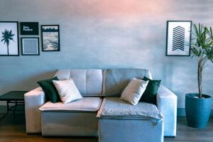 uma sala de estar com um sofá e um vaso de plantas em Studio a 100m Bosque, Centro e Cambuí- Home Office, Piscina, Sauna, Jacuzzi, Fitness em Campinas